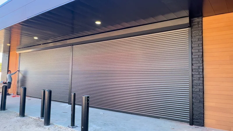 Rolluu silver security shutters installed over a glass storefront